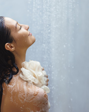 Serene Woman Relaxing in Shower with Lathered Loofah and Eyes Closedの写真素材