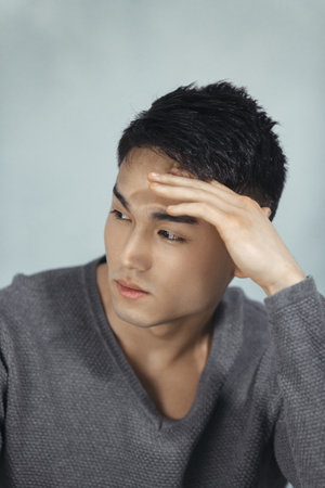 Thoughtful Asian Male Model In Gray Sweater, Contemplative Close-Up Shot