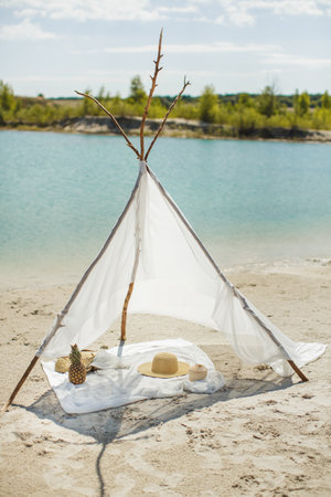 Handmade Sun Tent on Sandy Beach by Clear Blue Water