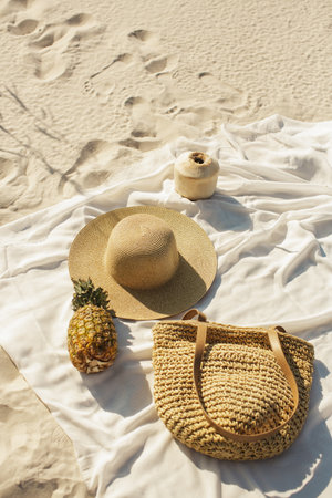 Beach Picnic Essentials Straw Hat, Pineapple, and Bag on Sandの写真素材