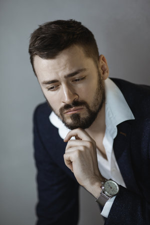 Thoughtful Businessman In Formal Suit With Hand On Chinの写真素材