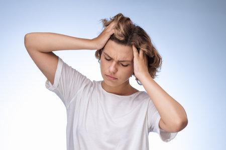 Young Woman Holding Head In Frustration And Pain From Stress Or Migraineの写真素材