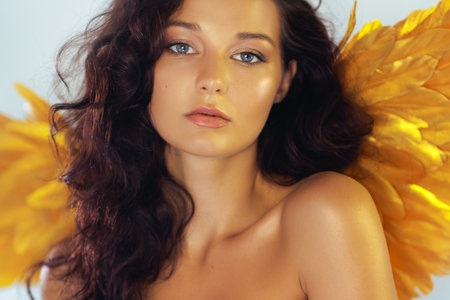 Close-Up of Seductive Angel Woman With Golden Wings and Bare Shoulders