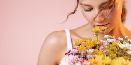Graceful Woman With Vibrant Flower Bouquet On Soft Pink Studio Backdrop