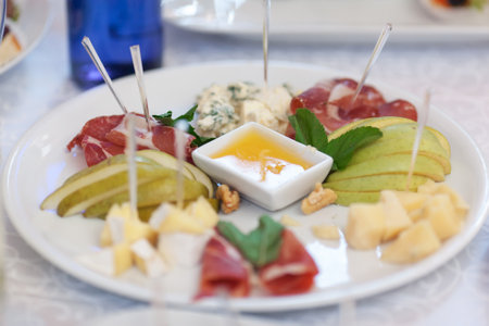 Gourmet Cheese And Charcuterie Platter With Fruits And Honey Dipの写真素材