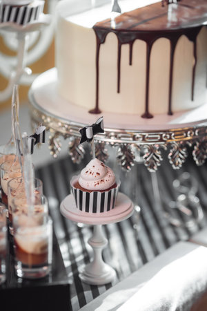 Sophisticated Dessert Setup with Drip Cake and Decorated Cupcakeの写真素材
