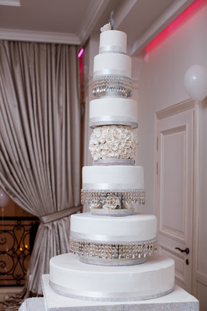 Grand White Tiered Wedding Cake with Crystals and Floral Detailsの写真素材