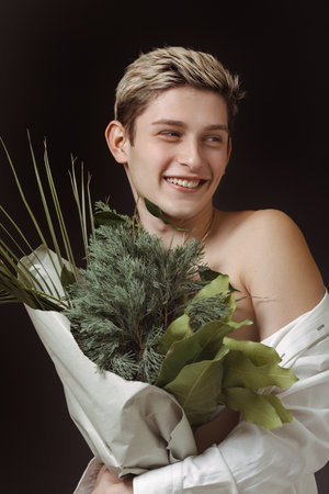 Smiling Young Man With Green Bouquet in Stylish Studio Portraitの写真素材