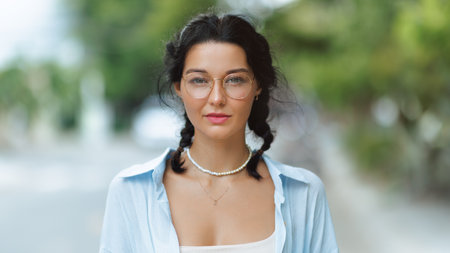 Stylish Young Woman with Braided Hair and Glasses on Urban Street