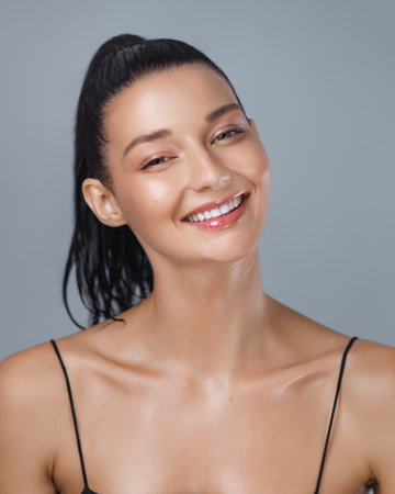 Happy Woman with Wet Skin Smiling After Workout in Minimalist Studioの写真素材