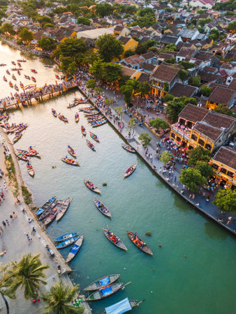 Vibrant Drone Shot Of Hoi An Riverside With Boats And Crowded Walkwaysの写真素材