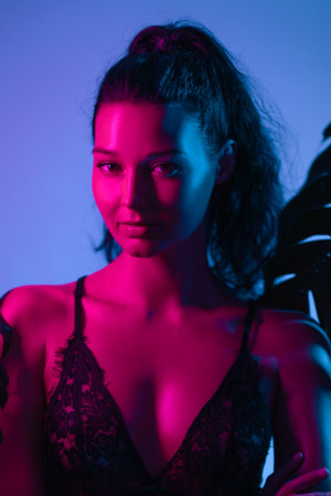 Glamorous Woman in Lace Lingerie with Bold Neon Pink and Blue Lighting