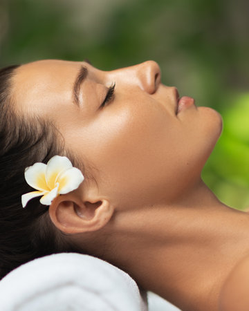 Close-Up Spa Portrait Of Woman With Flower In Hair And Calm Expressionの写真素材