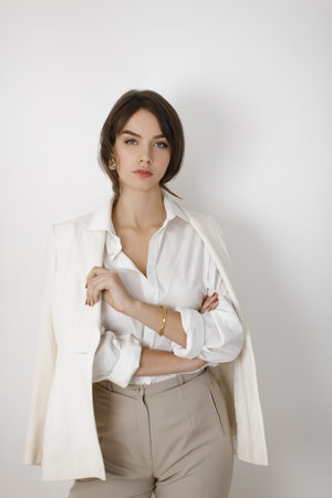Confident Woman in White Blazer and Neutral Outfit Posing with Elegance