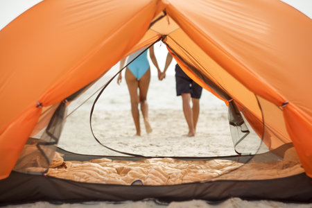 Couple Holding Hands Seen From Inside Orange Beach Tentの写真素材