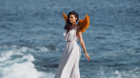 Elegant Fantasy Woman With Golden Wings and White Dress Walking by the Ocean
