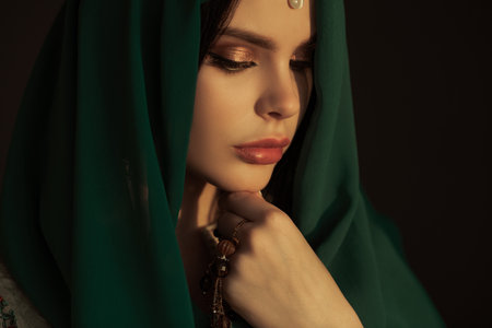 Serene Portrait of Woman in Green Veil With Closed Eyes and Jewelryの写真素材
