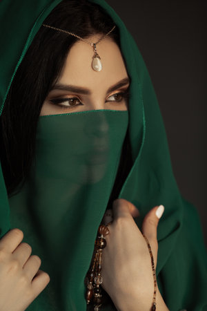 Mysterious Veiled Woman With Pearl Headpiece and Beaded Jewelry Poseの写真素材