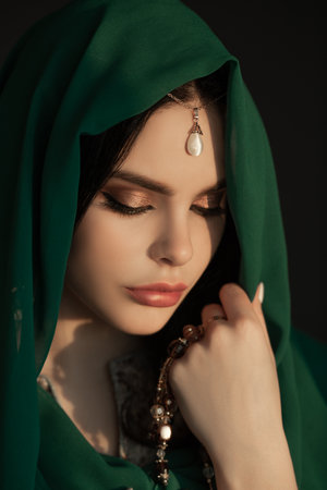 Tranquil Beauty of Woman in Green Hijab and Traditional Pearl Headpieceの写真素材