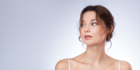 Natural Beauty Portrait of a Young Woman Looking Aside Thoughtfully in Soft Studio Lighting