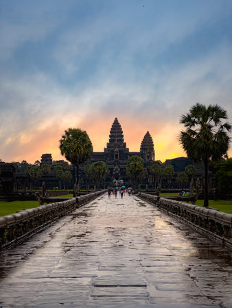 Sunrise View Of Angkor Wat Temple In Cambodia With Pathway And Palm Trees