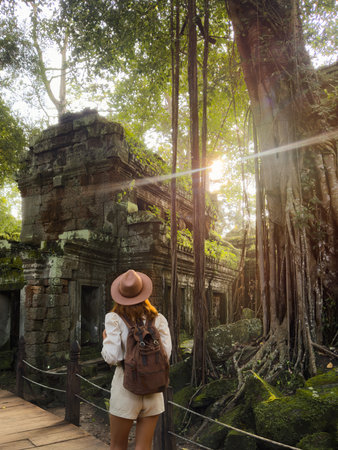 Female Traveler Admiring Ancient Ta Prohm Temple Ruins With Giant Rootsの写真素材