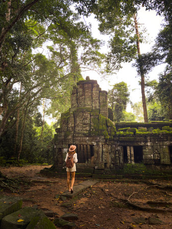 Female Tourist With Backpack Exploring Ancient Jungle Temple At Ta Prohm