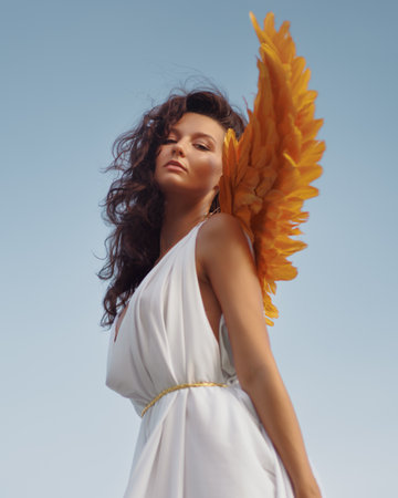 Fantasy Heroine Woman With Golden Angel Wings In Flowing White Dress Fairy Tale Lookの写真素材