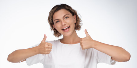 Excited Woman Giving Double Thumbs Up in White T-Shirt for Banner Adの写真素材