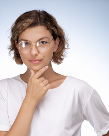 Thoughtful Woman in White T-Shirt Wearing Glasses on Blue Background