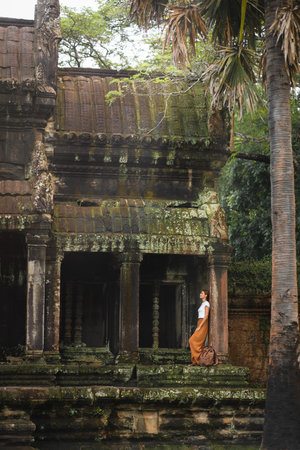 Traveler Woman With Backpack Exploring Ancient Angkor Wat Temple In Cambodiaの写真素材