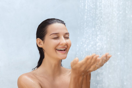 Happy Young Woman Enjoying Refreshing Shower With Glowing Skin Conceptの写真素材