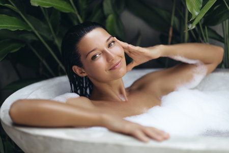 Smiling Woman With Glowing Skin Relaxing In Tropical Spa Foam Bathtub