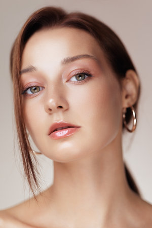 Close-Up Of Woman With Glowing Skin, Pink Eyeshadow And Hoop Earringsの写真素材