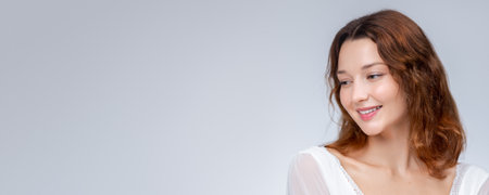 Natural Beauty Woman Smiling Gently In Bright Studio With Soft Lightの写真素材