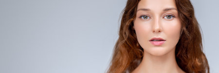 Beautiful Woman With Wavy Hair and Clean Glowing Skin in Studioの写真素材