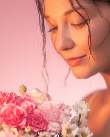 Peaceful Woman in Warm Light Smelling Pink and White Floral Bouquetの写真素材