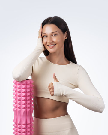Sport Woman Smiling With Foam Roller And Thumbs Up In Studio Wellness Shotの写真素材