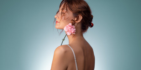 Dreamy Beauty Portrait Of Woman With Pink Flower And Soft Blue Backgroundの写真素材
