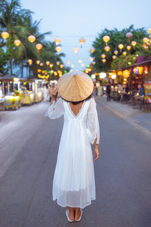 Woman in White Dress Walking Through Lantern Street Market in Hoi Anの写真素材