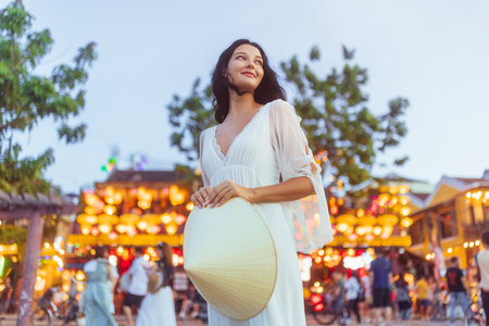 Smiling Woman with Conical Hat in Hoi An Lantern Street Market at Duskの写真素材