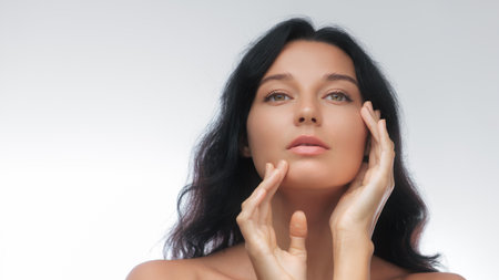 Natural Beauty Close-Up of Young Woman with Soft Hands Framing Her Faceの写真素材