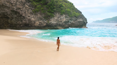Rear View Woman On Secluded Tropical Beach With Turquoise Surfの写真素材