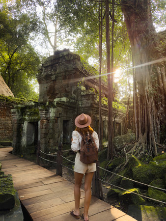 Sunlit Ta Prohm Jungle Temple Walkway With Female Traveler, Cambodiaの写真素材