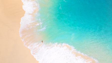 Woman Standing In Turquoise Shoreline On Bright Sandy Tropical Beachの写真素材