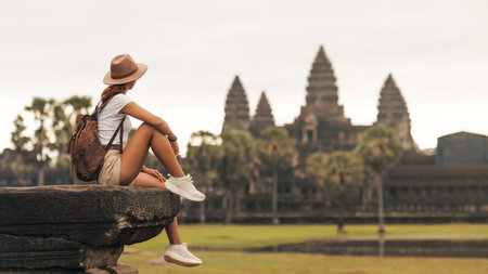Solo Female Traveler Admiring Angkor Wat Temple At Sunrise In Cambodiaの写真素材