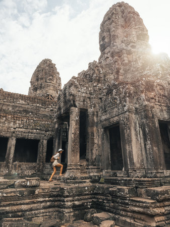 Female Traveler On Bayon Temple Steps At Sunrise, Angkor Thom, Cambodiaの写真素材