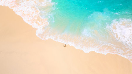 Serene Tropical Beach Waves Washing Over Lone Traveler On Sandy Shoreの写真素材