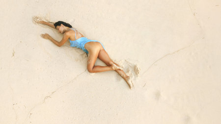 Serene Woman Relaxing On Sandy Tropical Beach In Soft Natural Daylightの写真素材