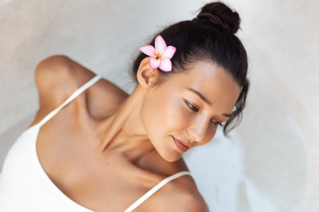 Top View Of Woman In White Swimsuit With Flower In Hair Looking Away Calmlyの写真素材
